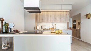 A modern kitchen with a central island, wooden cabinets, and a built-in oven.