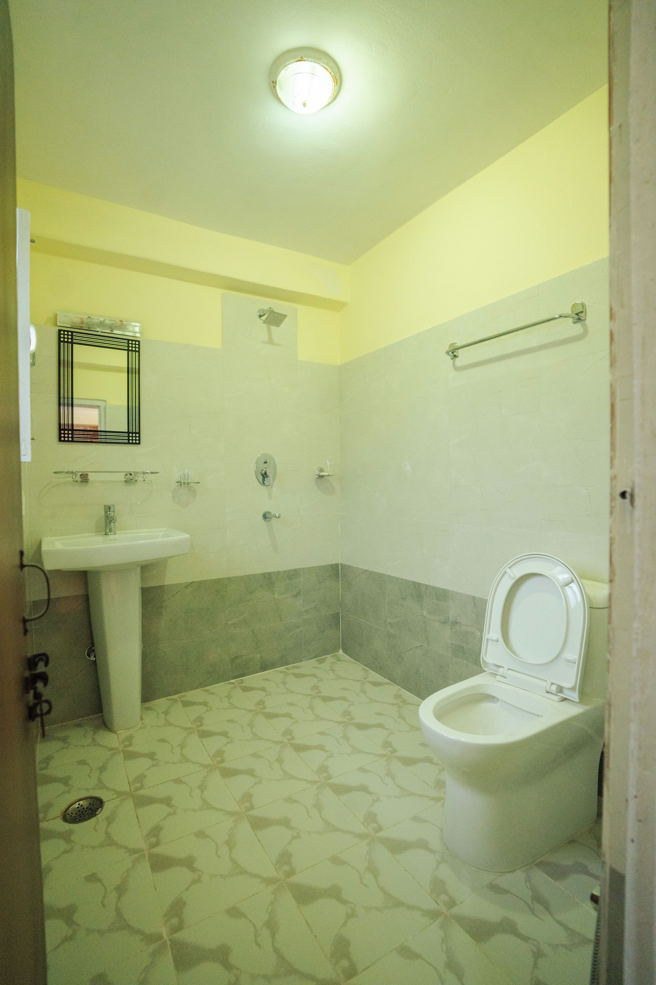 A bathroom with a toilet, sink, and shower.