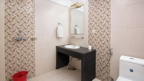 A bathroom with a sink, mirror, toilet, and shower. - Hotel Nomad Inn (Pokhara)