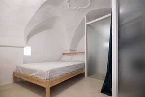 Cozy retreat with a single bed, arched ceilings, and a partial view.