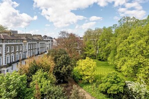 Un quartier résidentiel composé de maisons mitoyennes, d’une pelouse bien entretenue et d’arbres adultes.