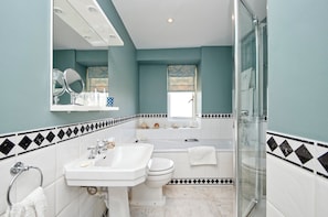 A bathroom with a white sink, toilet, and bathtub, a large mirror, and a shower area. - Beautiful & Spacious, 2 Bed in South Kensington (London)