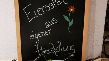 Eine Kreidetafel mit verschiedenen Gerichten und einem Smiley.