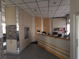 Cocina moderna con refrigerador empotrado, armarios de madera y encimera con cafetera.