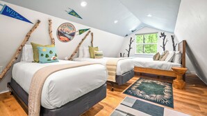 A bedroom with two beds, a wooden bench, and a large window.