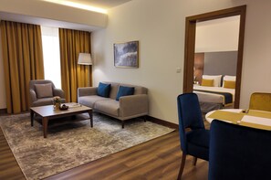 Suíte, 1 cama King | Área de estar | TV LCD 42 polegadas com canais a cabo, serviços de streaming