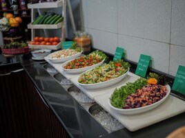 A buffet with various salads and vegetables displayed on trays.
