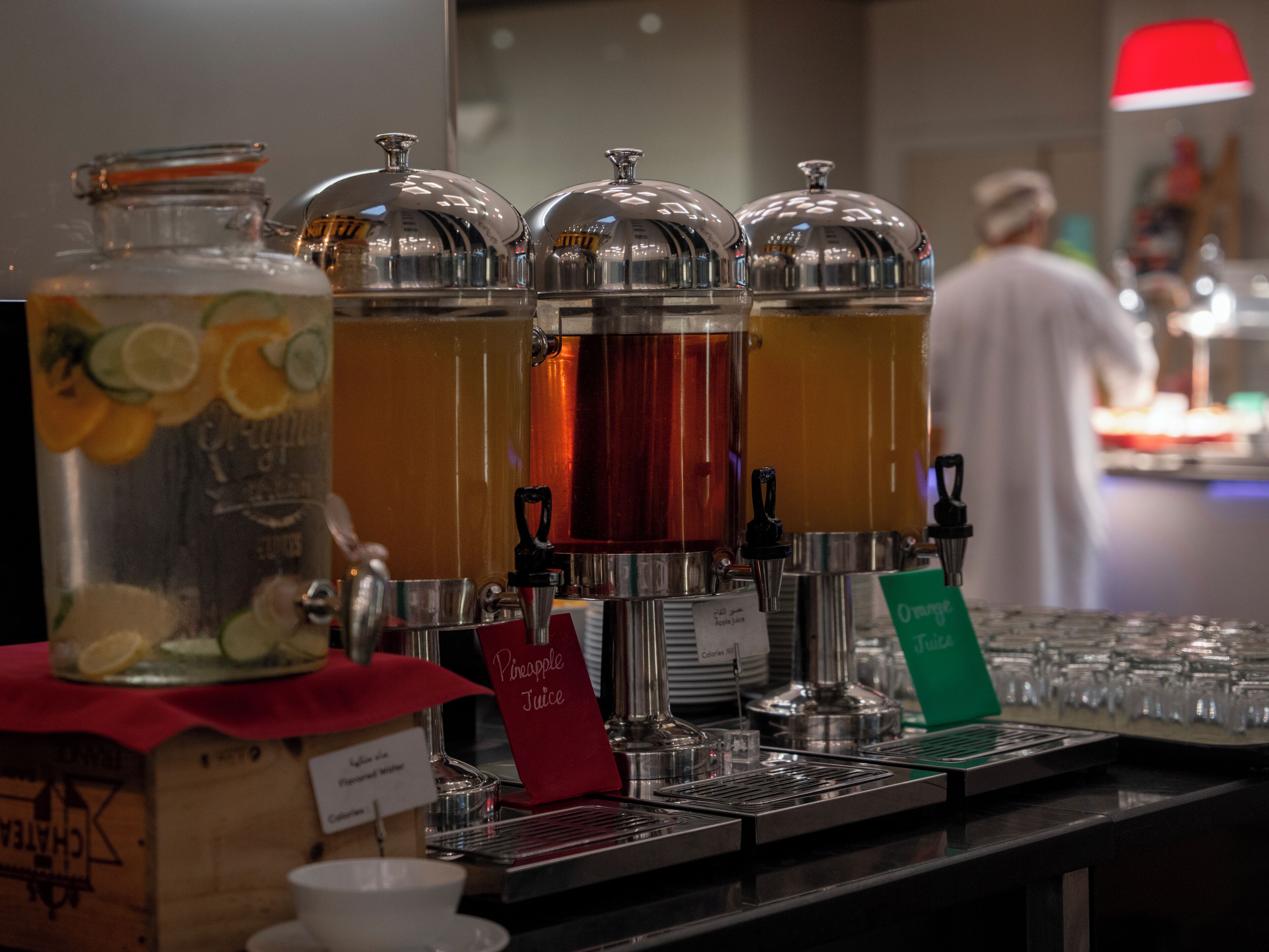 Un point de distribution de boissons doté de plusieurs distributeurs, dont un est étiqueté « jus d’ananas ».
