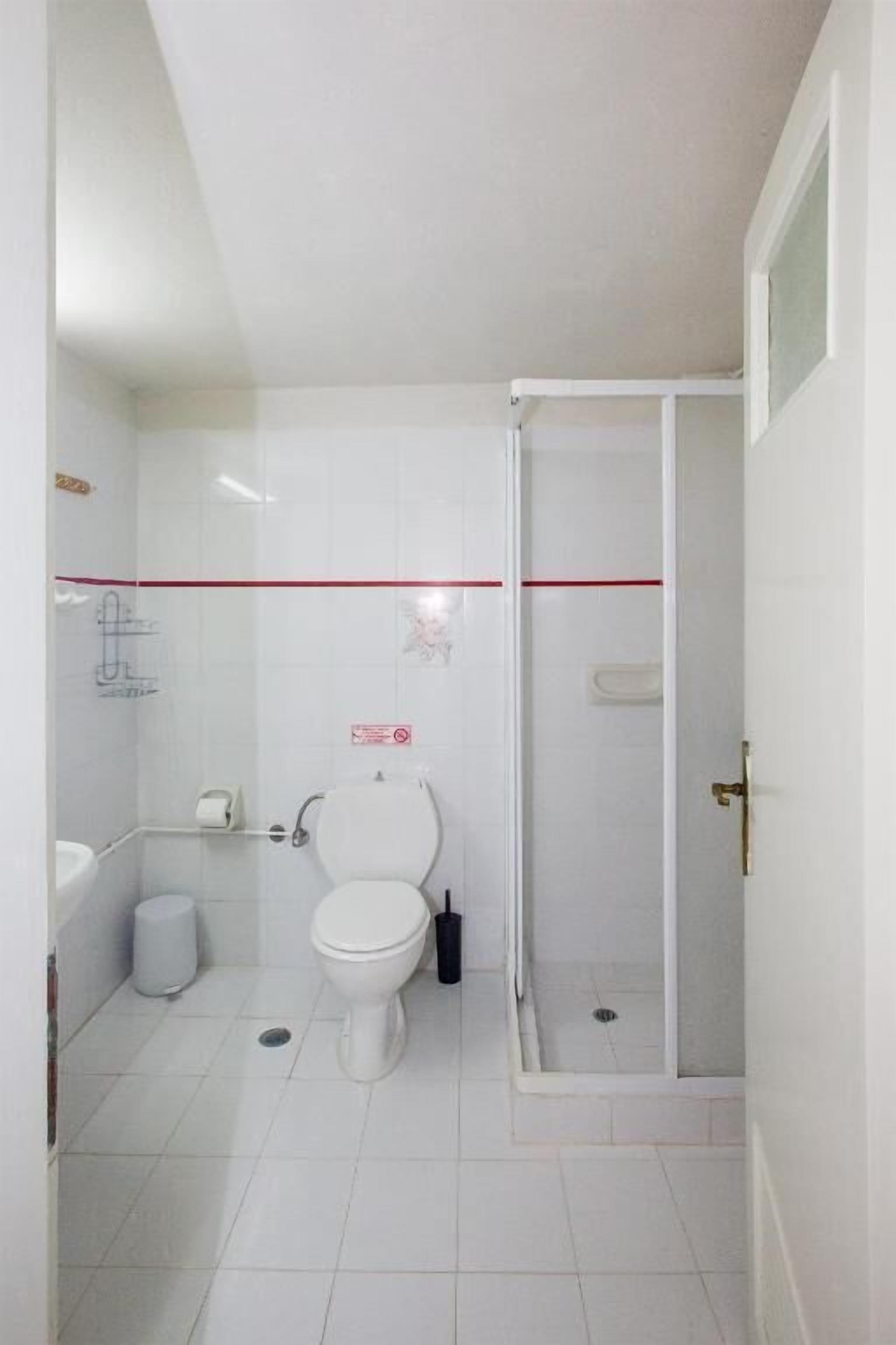 Ein kleines, sauberes Badezimmer mit Toilette, Waschbecken und Dusche.
