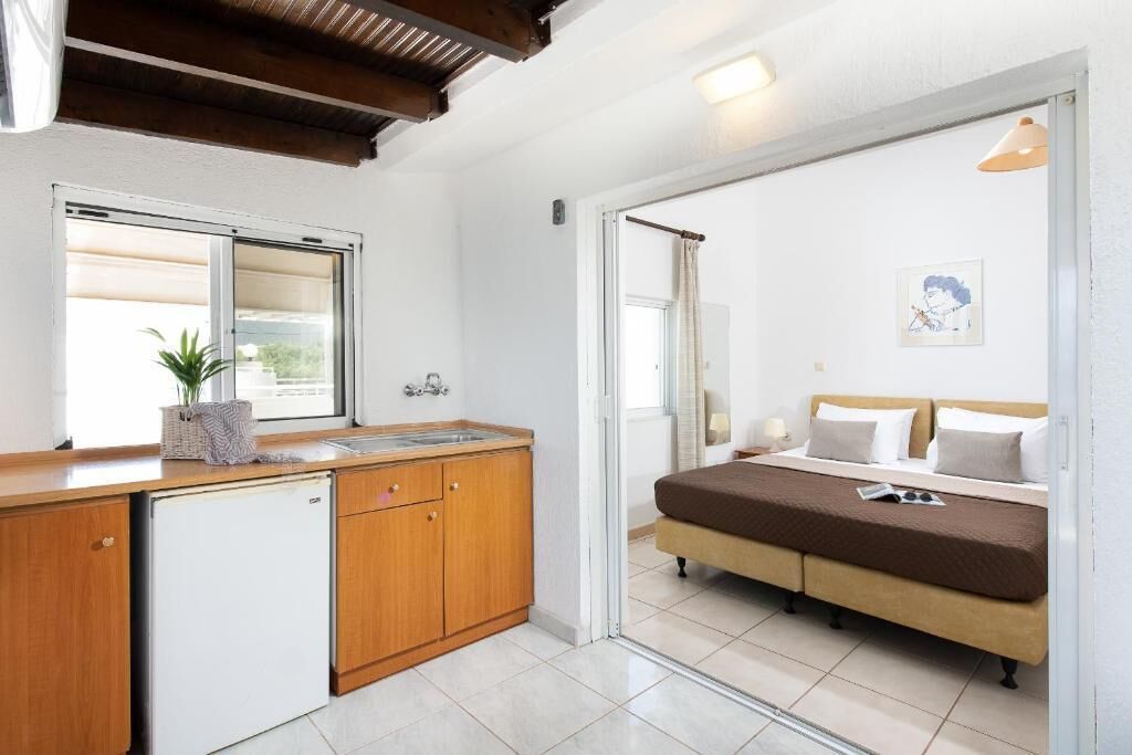 A compact bedroom with a bed, a bedside table, and a window.