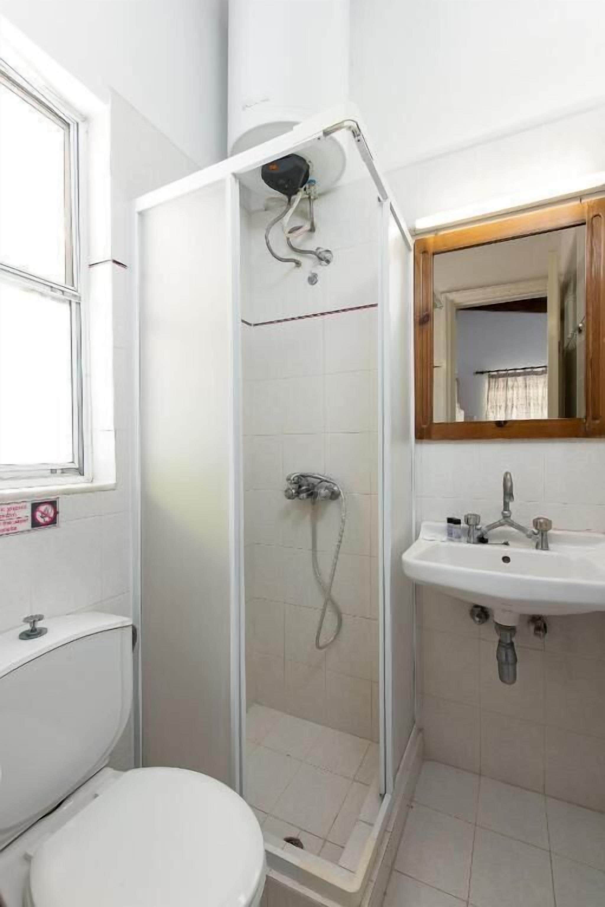 Une salle de bain comprenant des toilettes, un lavabo et un espace douche.