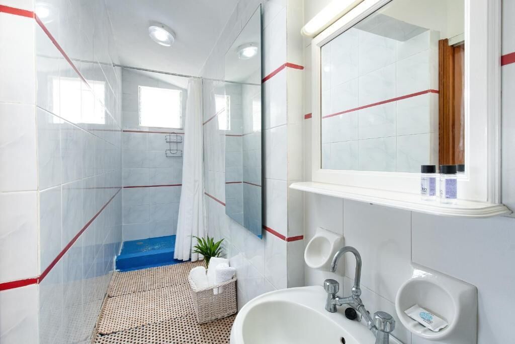 A modern bathroom with a shower, a sink, and a mirror.