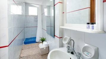 Un baño moderno con ducha, lavamanos y espejo.