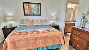 A bedroom with a bed, nightstands, a dresser, a mirror, and a painting on the wall. - Catalina Foothills Condo on the Golf Course (Tucson)