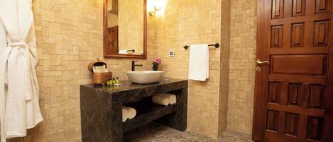 A bathroom with a marble sink, a wooden door, and a towel rack.