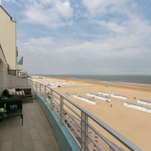 A balcony with a view of a sandy beach and the sea. - Panoramic Seaview Apartment in t Zoute (Knokke-Heist)