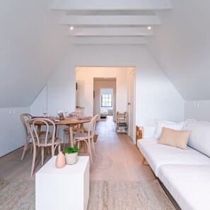 Ein modernes Loft-Schlafzimmer mit einem großen Bett, einem Essbereich mit Holzkästen und Blick auf die Stadt.