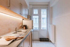 Modern kitchen with stainless steel sink, oven, and wooden countertop.