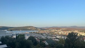 A coastal town with wind turbines, a marina, and residential buildings. - hotel budapest (Seferihisar)