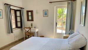 Une chambre à coucher avec un lit, un bureau, une chaise et une fenêtre avec des rideaux.