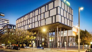 Een modern hotel met een plat dak en een bord waarop staat dat het een hotel is.