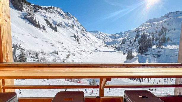 A wooden cabin with a view of a snowy mountain landscape.