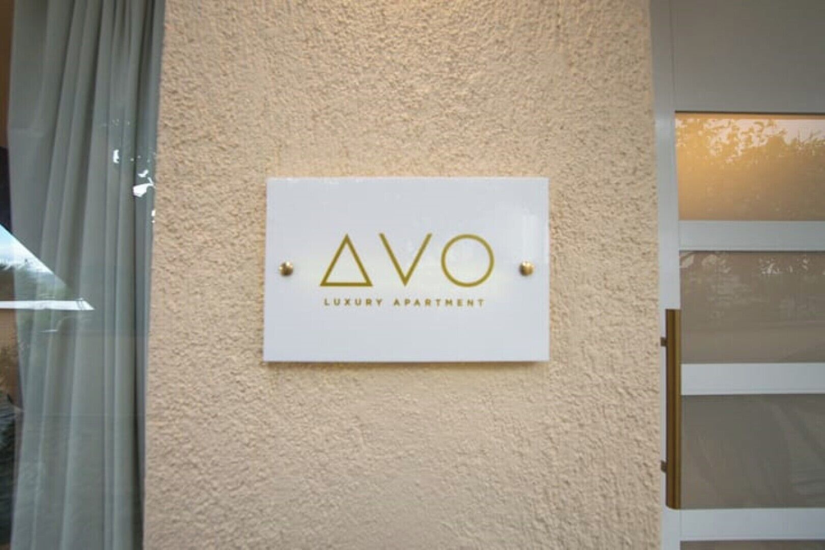 Cartell de l'apartament de luxe AVO fixat a una paret amb relleu.