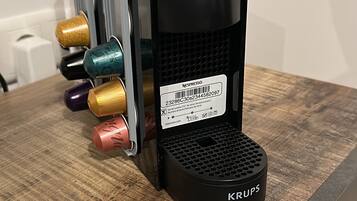 A coffee machine with multiple coffee pods on a wooden surface.