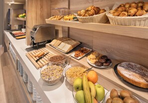 A buffet with various food items including fruits, pastries, and bread. - B&B Hotel Barcelona Sant Cugat (Sant Cugat del Valles)