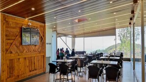 Un comedor moderno con paredes de madera y vistas a un grupo de personas afuera.