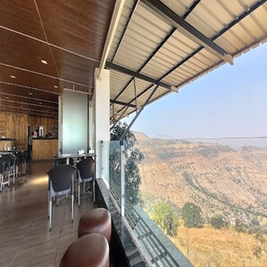 A restaurant with a view of a valley, wooden interior, and a bar area. - The Royal Heaven Resort (Wai)