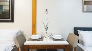 Ett välordnat matbord med två vita tallrikar, en vas med en enda vit blomma och två glas vatten.