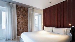 Une chambre moderne avec un grand lit, un mur en briques et un mur recouvert de panneaux en bois.