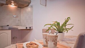 A kitchen area with a tray containing a bowl of food, a plant, and two decorative cups. - Ruby Apartment (Αγιος Νικολαος)