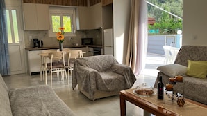 Una sala moderna con un sofá, una mesa de centro y un comedor con mesa y sillas.