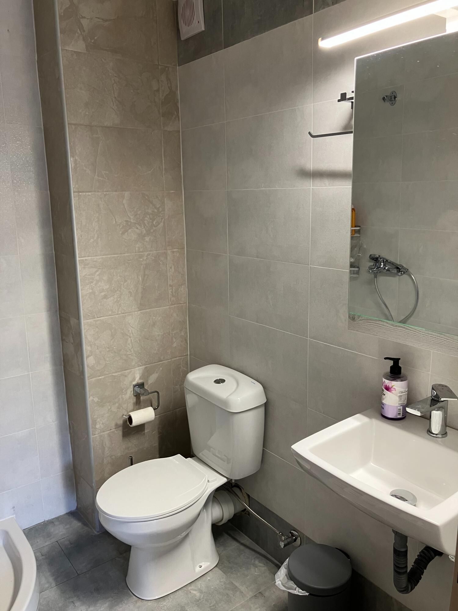 A modern bathroom with a toilet, bidet, and sink.