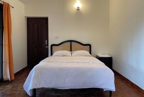 A single bed with a headboard, a bedside table, and a wall-mounted light fixture. - Nashika Villa by evaddo stays (Kodaikanal)