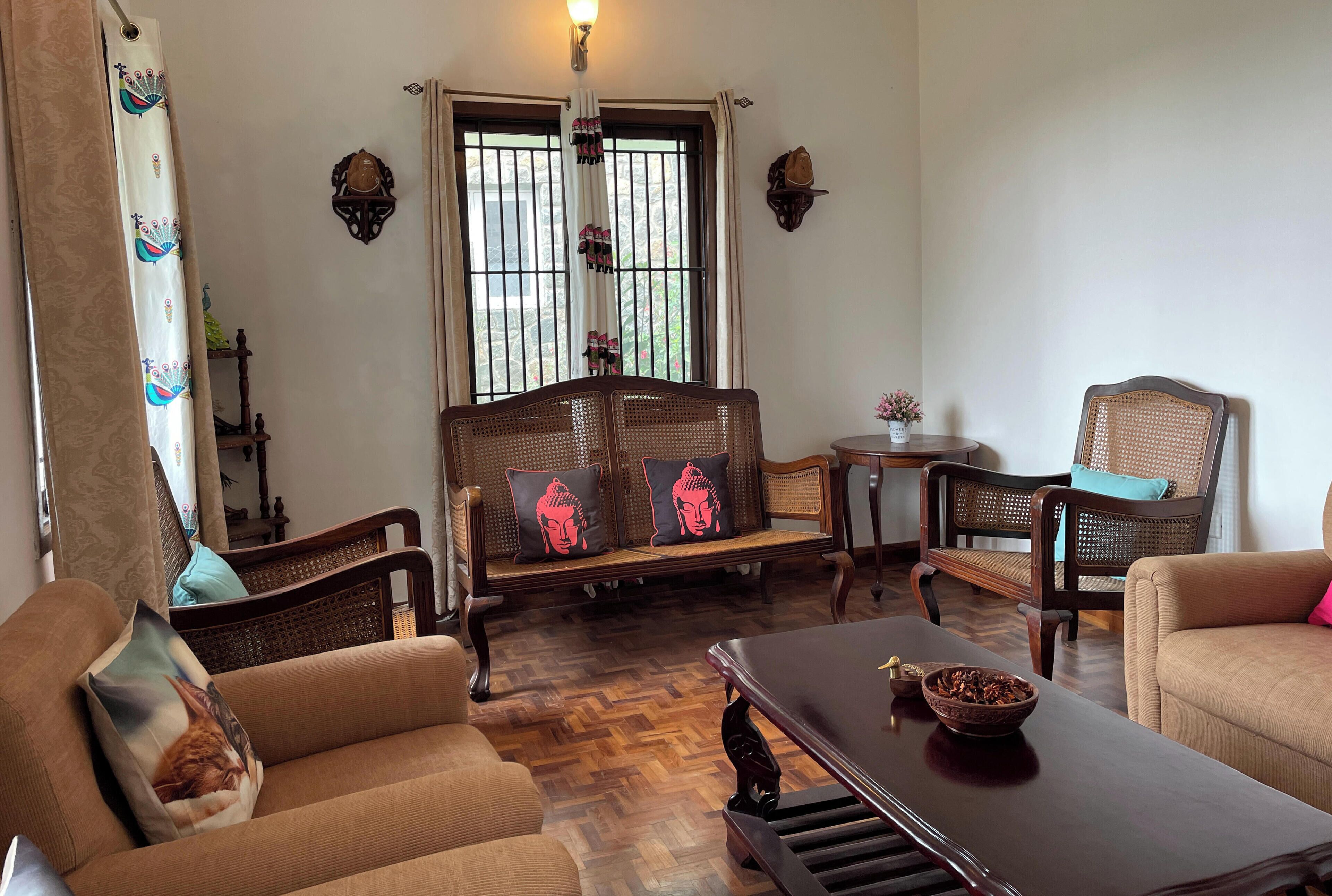 A traditional room with a sofa, chairs, a table, and a decorative wall.