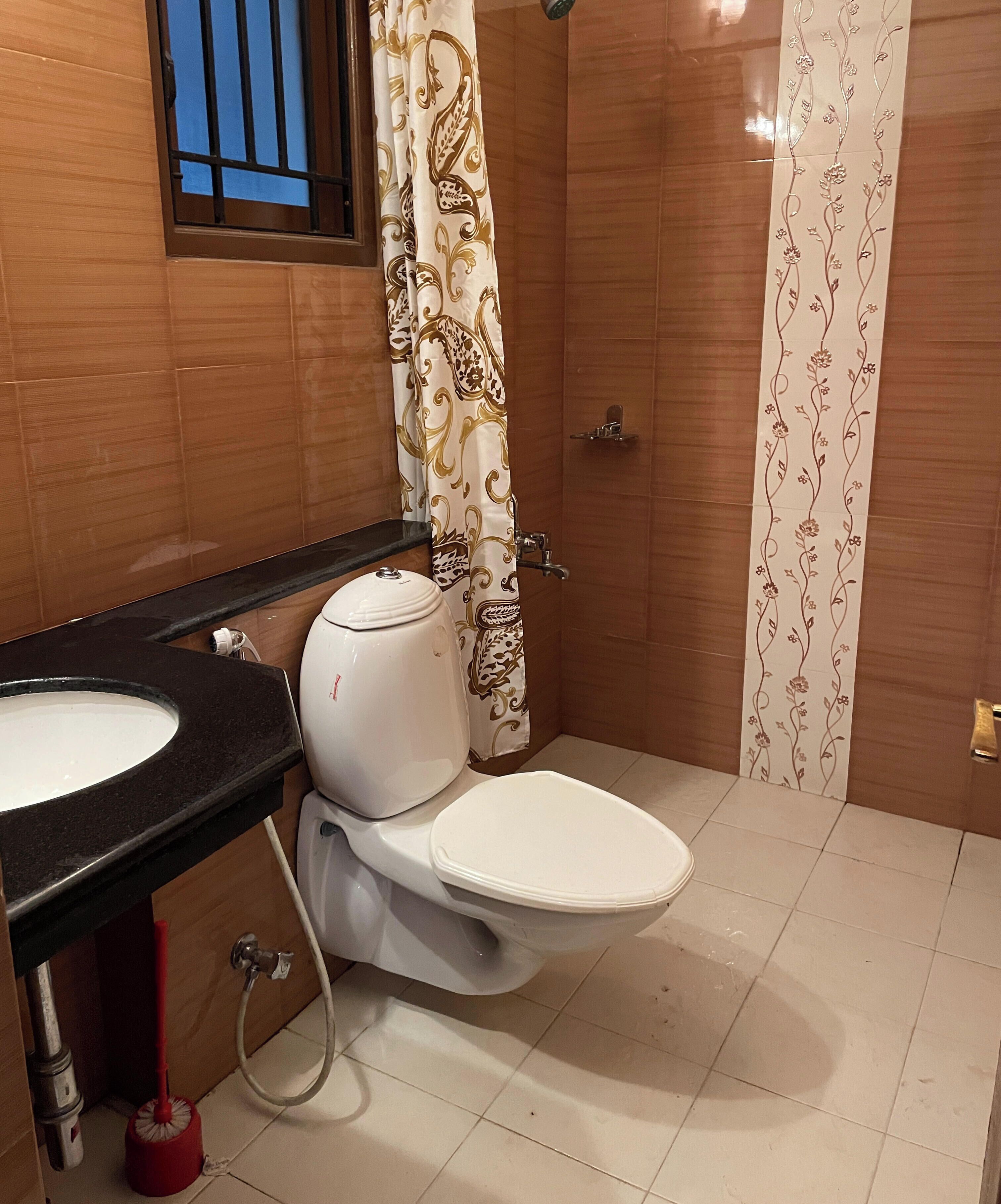 Un bagno con toilette, lavandino e tenda doccia.