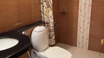 Une salle de bain avec des toilettes, un lavabo et un rideau de douche.