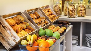 Un buffet de petit-déjeuner proposant une variété de viennoiseries, de fruits et de produits laitiers.