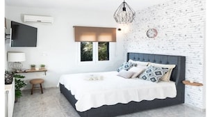 Ein modernes Schlafzimmer mit Bett, Schreibtisch und Fenster.