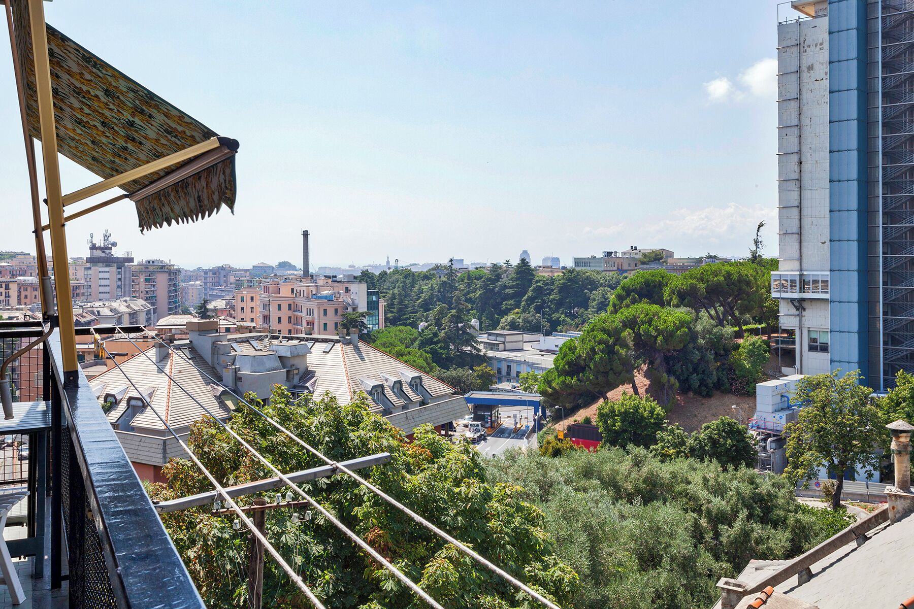 Terraza en la azotea con vistas a un paisaje urbano, con edificios y árboles.