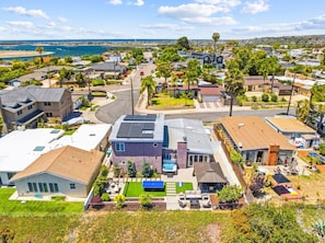 Un barrio residencial con casas, piscina y vista al océano.