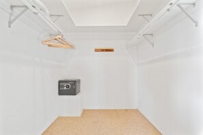 A minimalist room with a ceiling light, a hanging clothes rack, and a safe. - Bay Park Retreat with Backyard Fire Pit, Hot Tub, Ping Pong & Cornhole (San Diego)