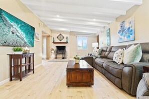 A spacious living room with a fireplace, a large sofa, and a wooden coffee table.