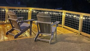 An outdoor deck with two Adirondack chairs and a wooden railing. - Antler Ridge Cabin One (Murfreesboro)
