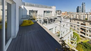 Un appartement moderne doté d’un balcon, de grandes fenêtres et offrant une vue sur la ville.