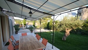 An outdoor patio with a wooden table and orange chairs, covered by a white canopy. - Family-friendly, Cozy and Peaceful Villa with Pool in Apt en Luberon, Provence (Apt)