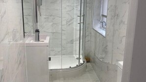 A modern bathroom with a glass-enclosed shower, a toilet, and a vanity with a mirror. - Brownlows Inn Rooms  (Liverpool)